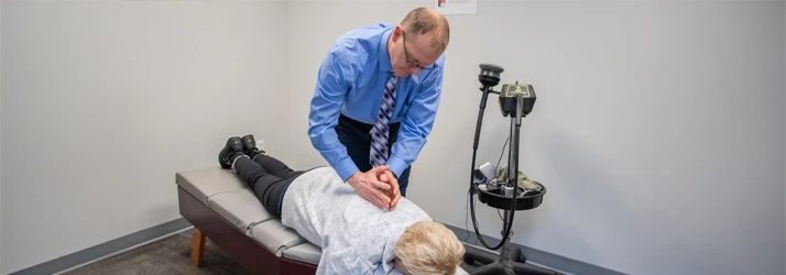 Dr. Todd Dorval delivering a back adjustment to a female patient