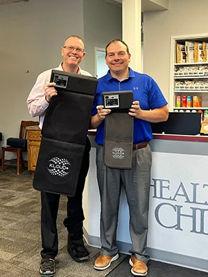 Drs. Todd Dorval Tyler Leintz, chiropractors at Health & Wellness Chiropractic Center, holding KLOUD equipment